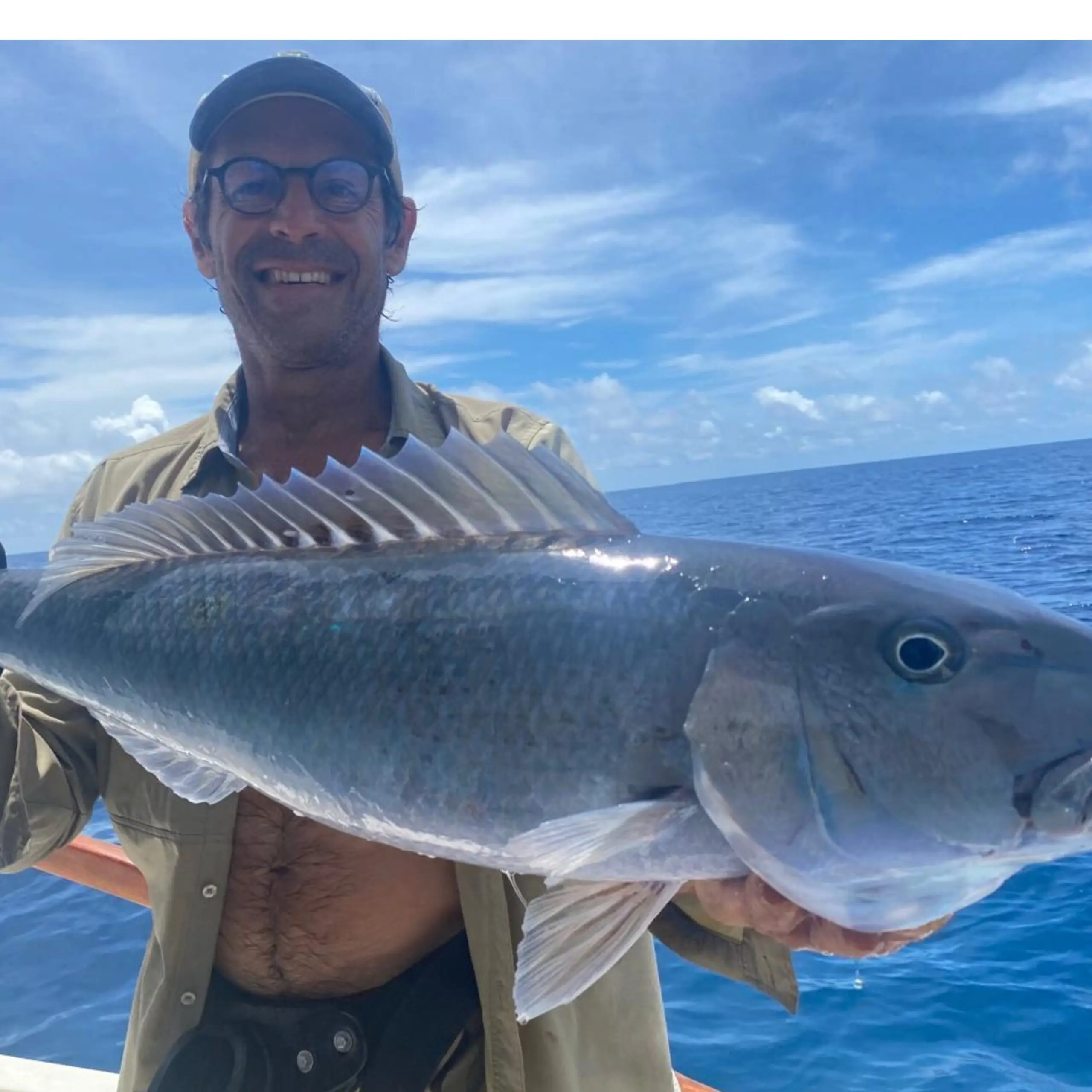 Fisherman holding a Jobfish in Seychelles waters near Remire before release