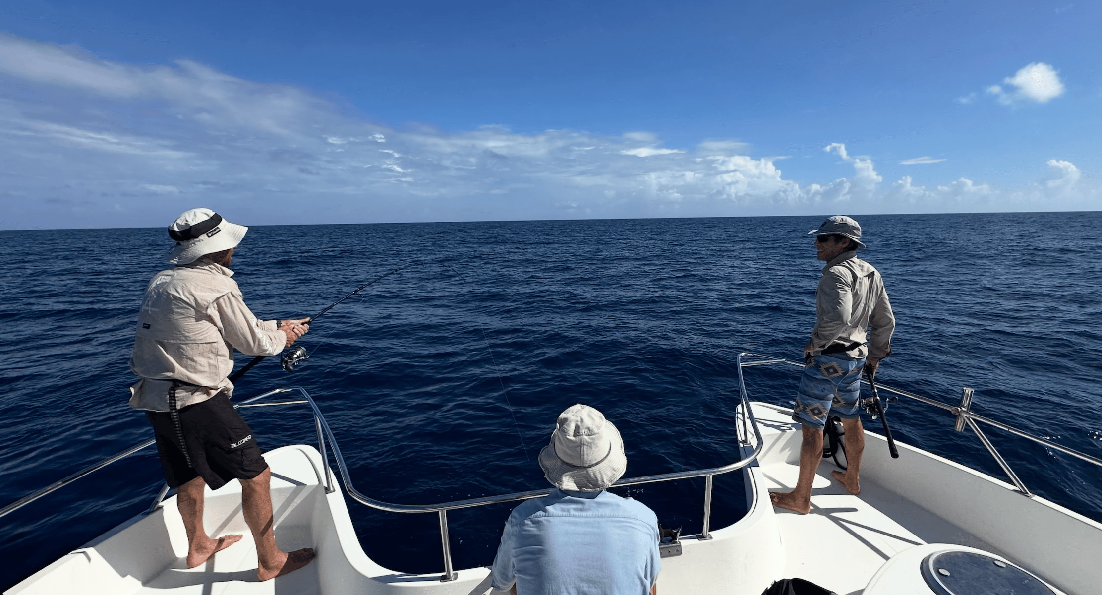 Fishing trip on a boat in the open sea with three anglers enjoying the day. Offshore fishing action in the Amirantes Seychelles focused on sustainable catch and release