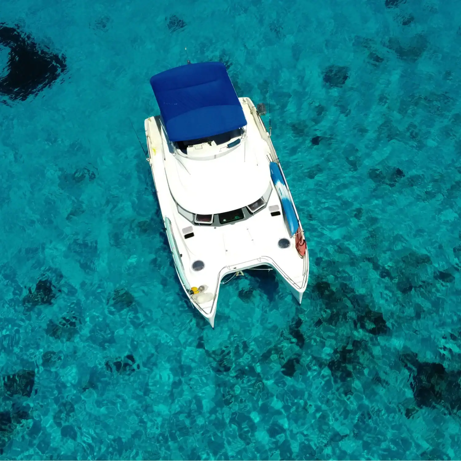 Luxury fishing boat anchored in clear blue waters for deep-sea angling adventures. Perfect for targeting blue marlin, yellowfin tuna, and exploring thermoclines. Fontaine Pajot Maryland 37 power catamaran anchored at sea under clear skies